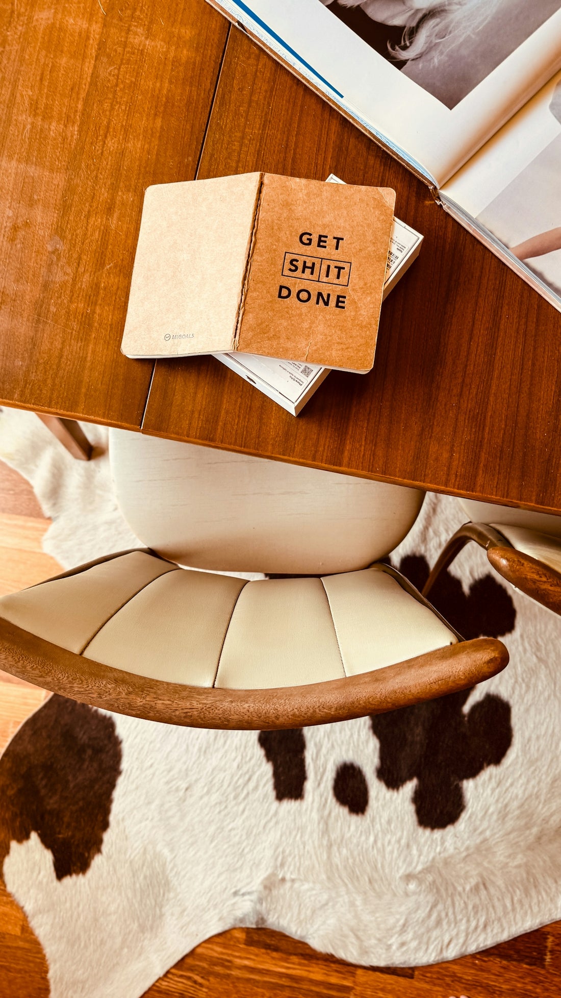 a cow rug and a chair with a book on top of it