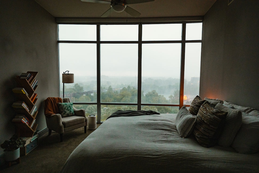 A bedroom with a large window and a bed