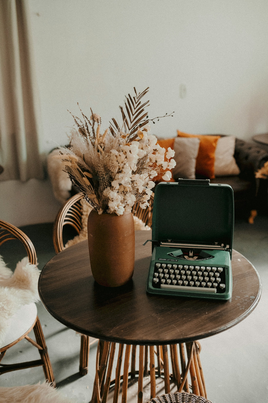 A living room with a couch, table and a typewriter